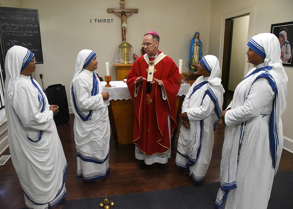 Archbishop Charles Thompson of Indianapolis speaks Sept. 21 with four Missionaries of Charity after celebrating Mass for them at the congregation's Our Lady of Peace Convent, located in one of the city's poorest neighborhoods. The sisters are, from left, 