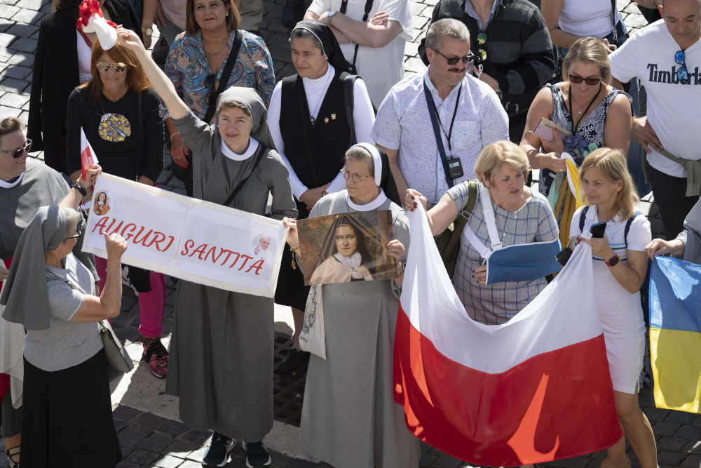 People in St. Peter's Square attend the Angelus led by Pope Francis from the window of his studio overlooking the square at the Vatican Oct. 2, 2022