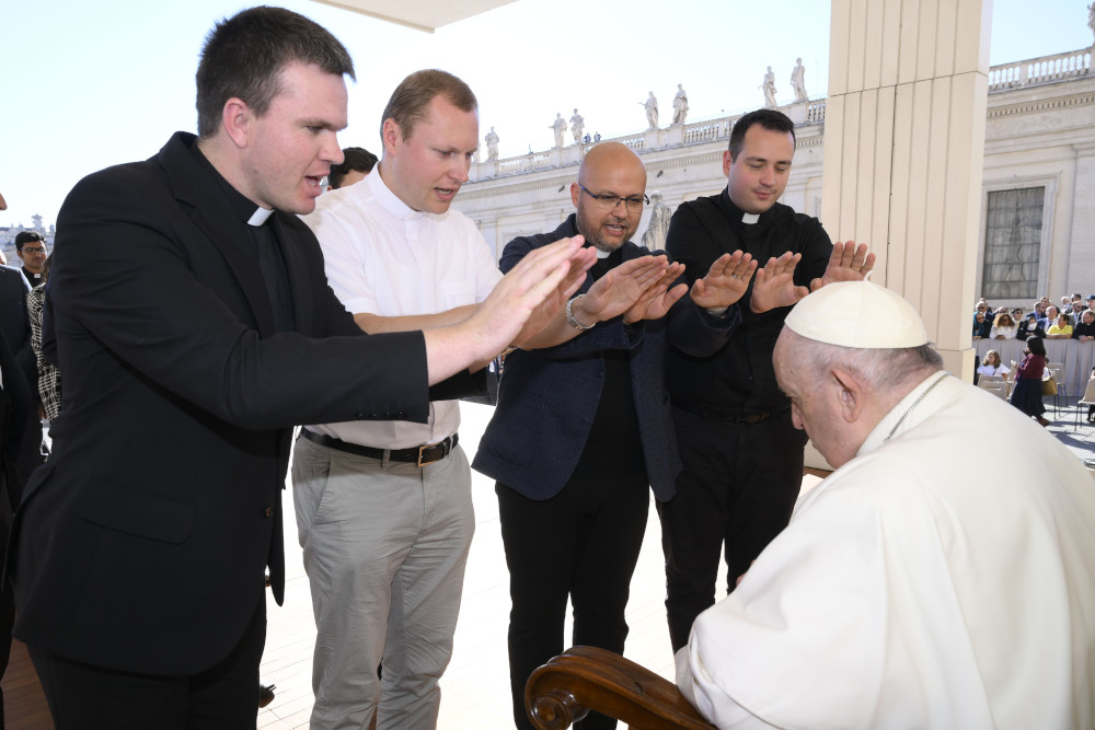 Priests pray over Pope Francis during his general audience in St. Peter's Square at the Vatican Oct. 5, 2022