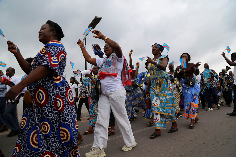 Women wave Congolese flags during a march to protest escalating violence in Congo, in Kinshasa Dec. 4, 2022. (CNS/Reuters/Justin Makangara)