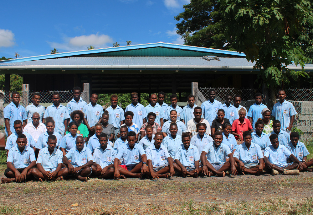 San Isidro Care Centre students and staff pose for a group photo in October 2021 outside the center's workshop. Sr. Maria Fe Rollo is seated, fifth from the right, in the middle row. (Courtesy of Maria Fe Rollo)