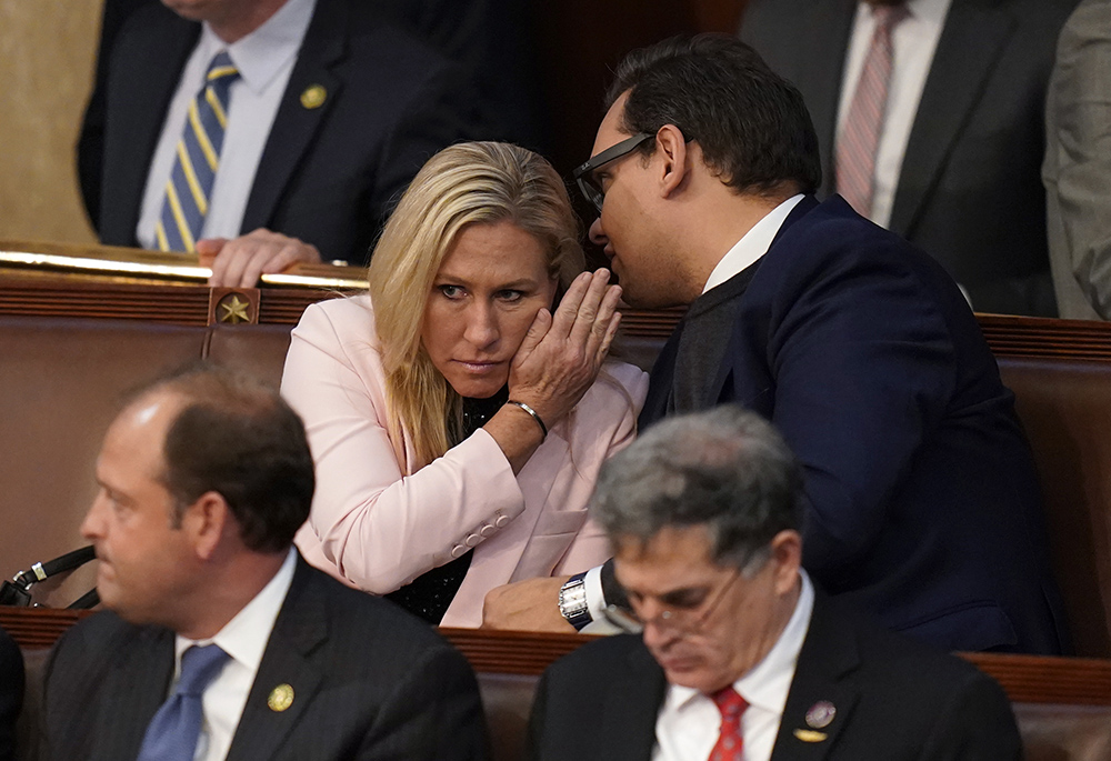 Rep.-elect George Santos, R-N.Y., right, talks with Rep. Marjorie Taylor Greene, R-Ga., during the ninth vote in the House chamber as the House meets for the third day to elect a speaker and convene the 118th Congress Jan. 5 in Washington. (AP photo/Alex Brandon)