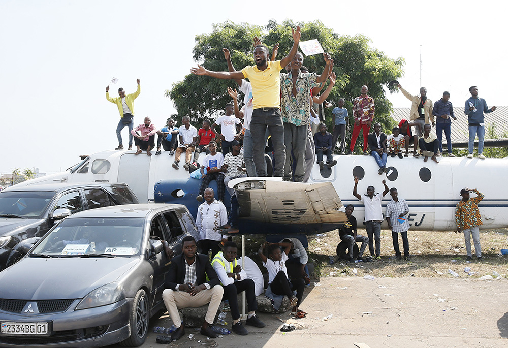 Young people stand on the wing of a retired airplane as Pope Francis celebrates Mass at Ndolo airport Feb. 1 in Kinshasa, Congo. (CNS/Paul Haring)