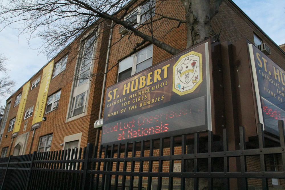 A brown brick building with a "St. Hubert Catholic High School for Girls Home of the Bambies" sign out front