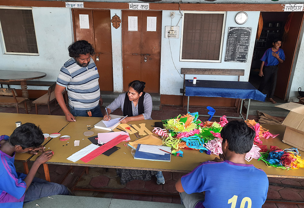 Sr. Ambika Pillai signs documents while preparing decorations for Christmas and New Year with boys under her care in Navjeevan. (GSR photo/Saji Thomas)