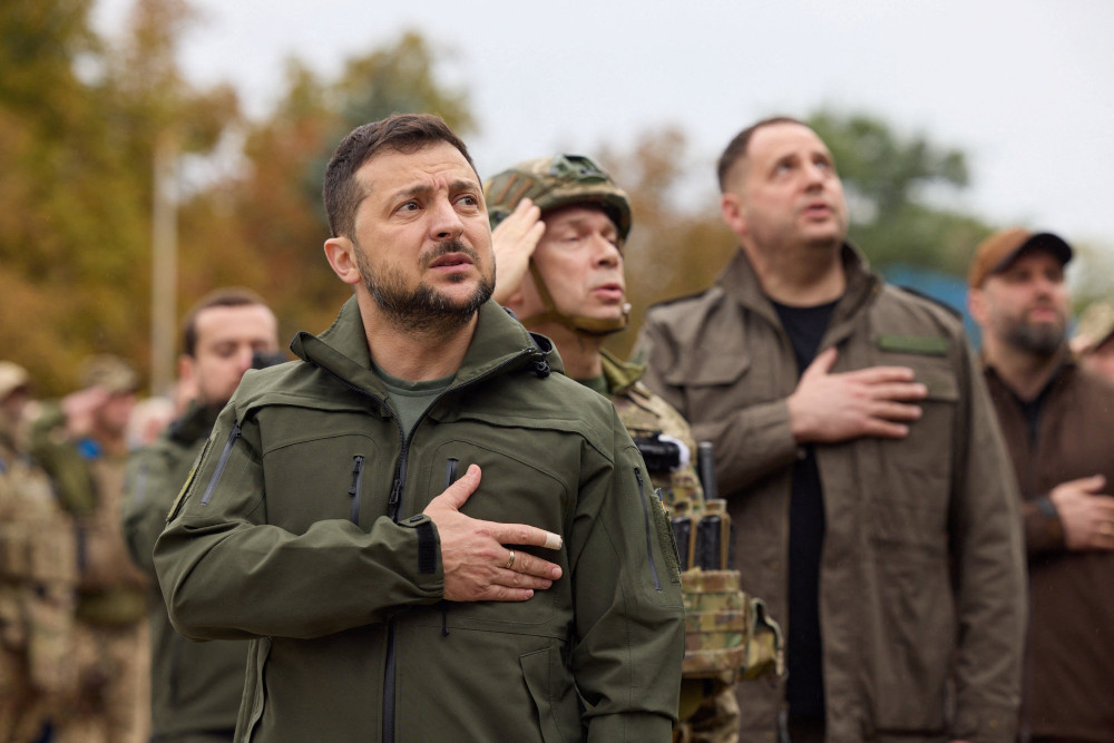 Ukrainian President Volodymyr Zelenskyy is pictured singing the national anthem during a flag-raising ceremony in Izium Sept. 14, 2022, after Ukrainian forces recaptured the city. (OSV News/Ukrainian Catholic Church) 