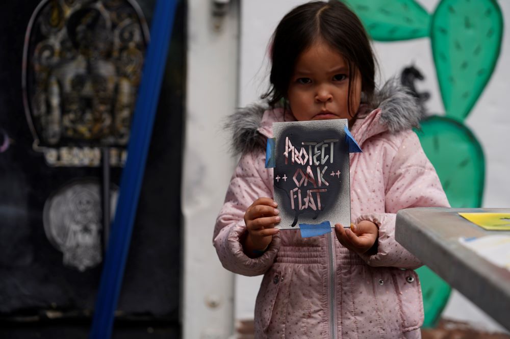 Apache Stronghold member Raetana Manny, 4, shows a sign to save Oak Flat