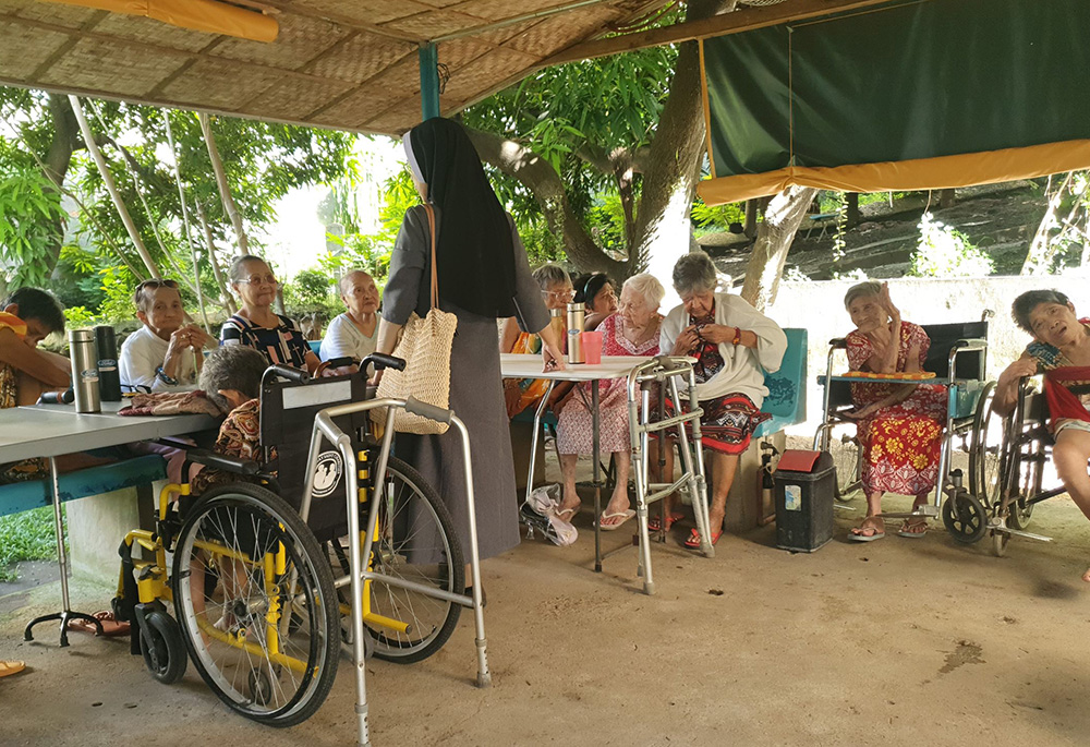 Los residentes del Hogar María Madre de la Misericordia para Ancianas y Desamparadas de San Pedro (Laguna, Filipinas) se reúnen en la cabaña exterior del recinto para rezar la coronilla de la Divina Misericordia y el rosario; allí también ven la televisión. (Foto: Oliver Samson)