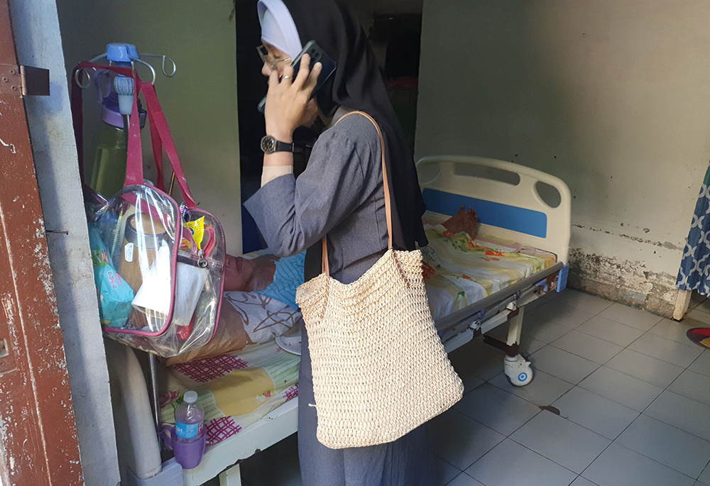 Sr. Venus Marie S. Pegar, vocation director of the Sisters of St. Francis Xavier's community in the Philippines, checks on a bedridden resident of Mary Mother of Mercy Home for the Elderly and Abandoned. (Oliver Samson)