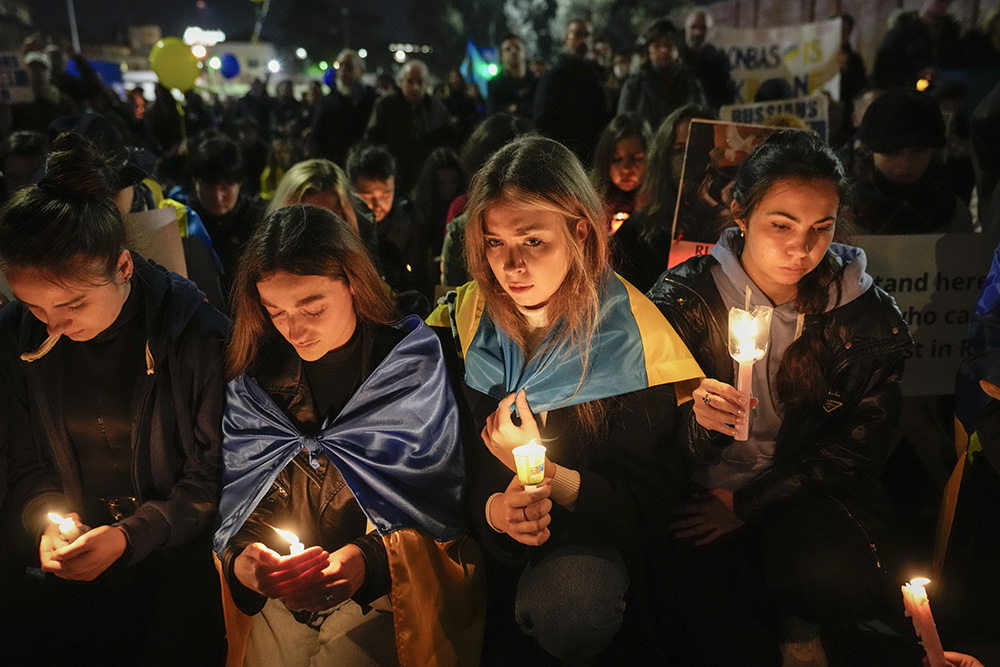 People carrying Ukrainian national flags and anti-war signs participate in a torchlight procession in the district where the Russian Embassy is in Rome Feb. 24, 2023, on the first anniversary of the Russian invasion of Ukraine. (AP/Alessandra Tarantino)