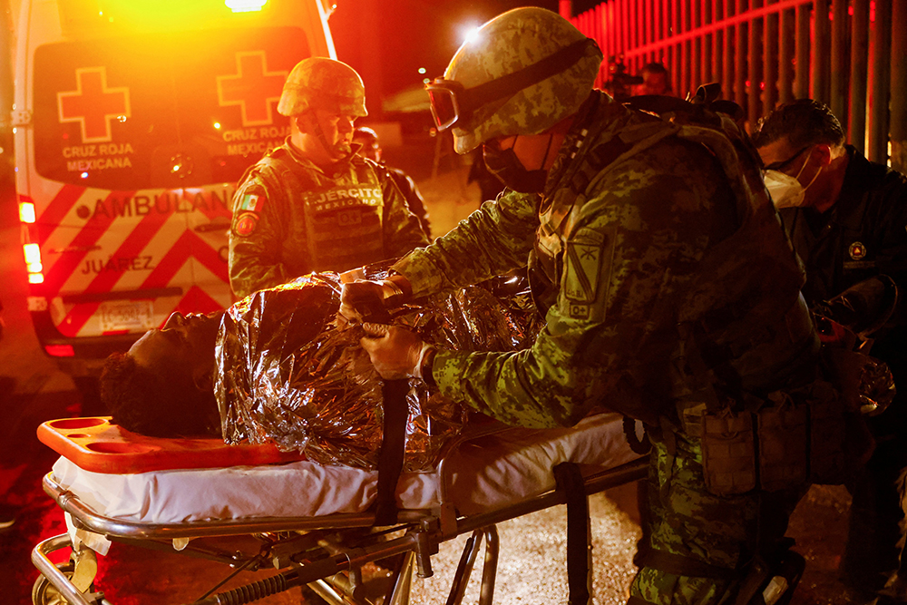 Mexican authorities and firefighters remove injured migrants, mostly Venezuelans, from inside the National Migration Institute building during a fire in Ciudad Juarez, Mexico, on March 27. (OSV News/Reuters/Jose Luis Gonzalez)