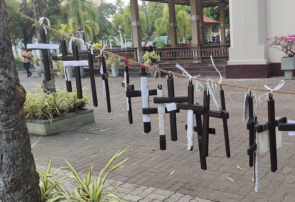 People tie a cross to a rope during Lent, a new practice that began after the 2019 Easter bombing at St. Sebastian's Church, most often done by relatives of those killed in the blast. (Thomas Scaria)