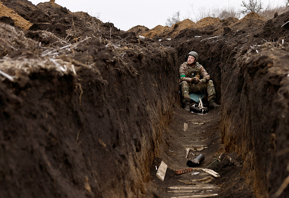 A Ukrainian soldier listens to artillery fire from his bunker at a front-line position near Bakhmut March 16, amid Russia's attack on Ukraine. (OSV News photo/Reuters/Violeta Santos Moura)