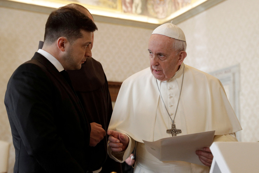 President Volodymyr Zelenskyy, wearing a suit, stands next to Pope Francis while in conversation