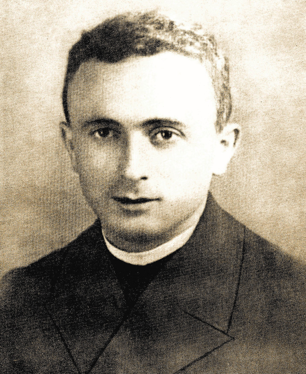 A black and white photo of a white man in a clerical collar