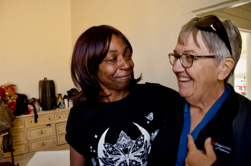 Carla Robinson, left, hugs Sr. Mary Agnes Cashman March 15 in Selma, Alabama, after showing Cashman the repairs and donated items she received after a tornado tore off her roof in January. (GSR photo/Dan Stockman)