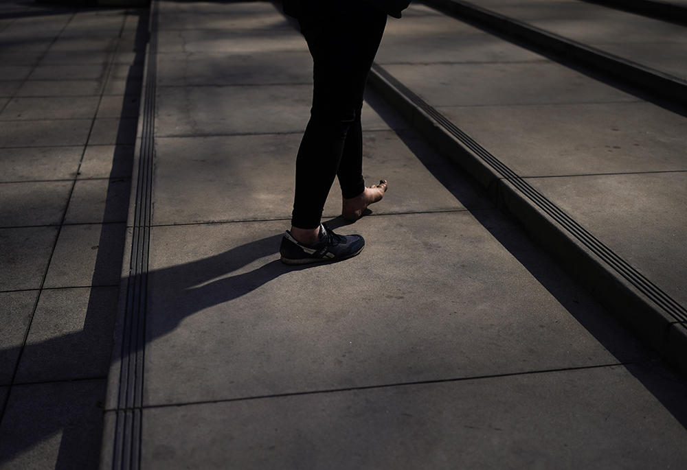 A half-barefooted homeless man walks up the steps April 14, 2022, in Los Angeles. (AP photo/Jae C. Hong)