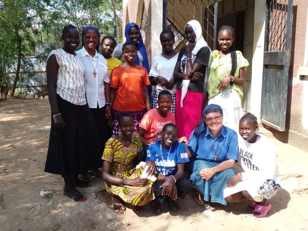 Srs. Elizabetta Grobberio (front row) and Sabina Mueni (second from left) pose with refugees in Kakuma Refugee Camp. Religious sisters hold weekly meetings to teach the refugees about forgiveness and reconciliation. (Courtesy of Missionary Sisters of Charles De Foucauld)