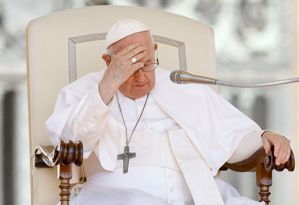 Pope Francis places his hand on his forehead during his weekly general audience in St. Peter's Square June 7 at the Vatican. (CNS/Lola Gomez)