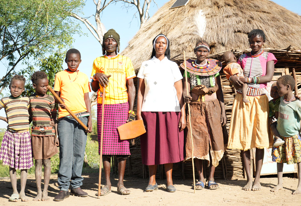 Sr. Jannifer Hiuhu with Cheposolowitch Akoler, her husband, her three youngest children, and her neighbor with her children (at right). The tiny village enclosure consists of three families who have settled near the Incarnate Word Sisters' mission facilities and the church's borehole, which is their only source of water amid a drought in East Pokot. (GSR photo/Wycliff Peter Oundo)