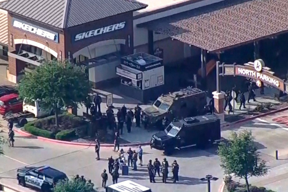 Military-style vehicles and people in dark outfits mill outside a Sketchers in a mall