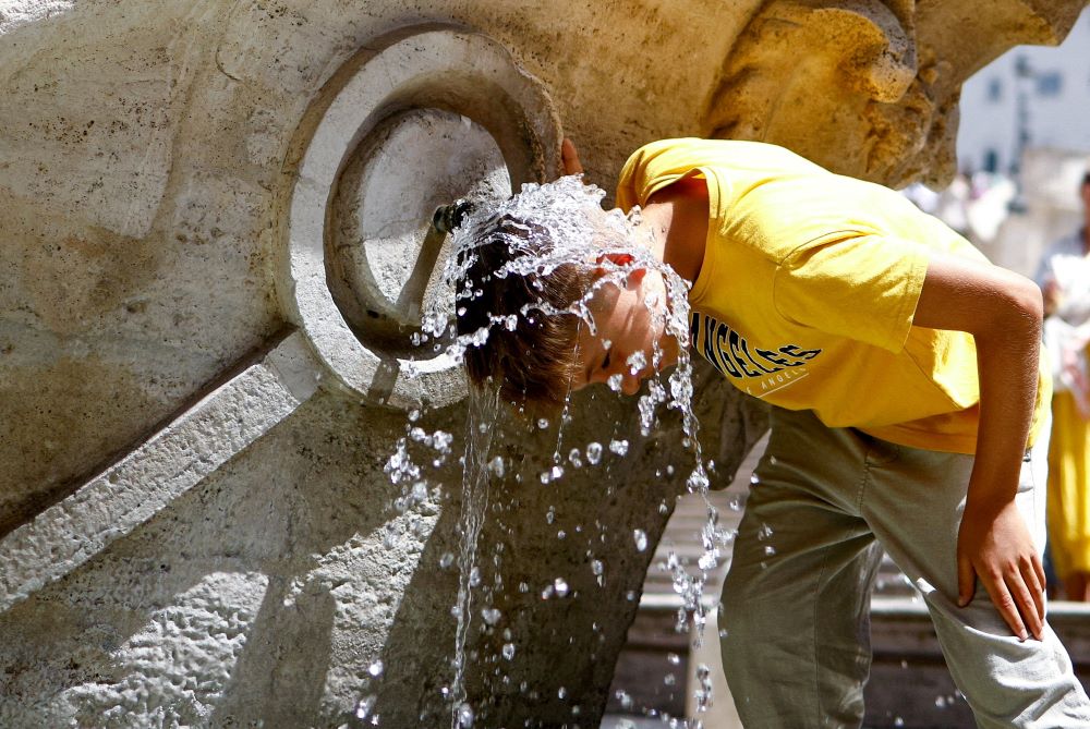 A boy cools off at Fontana della Barcaccia at the Spanish Steps in Rome July 17, 2023, during a heat wave across Italy as temperatures are expected to rise further in the coming days. Extremely high temperatures are expected to continue across parts of southern Europe this week, as the continent braces for its second extreme heat wave, putting people’s health at risk and setting the stage for wildfires. (OSV News/Reuters/Guglielmo Mangiapane)