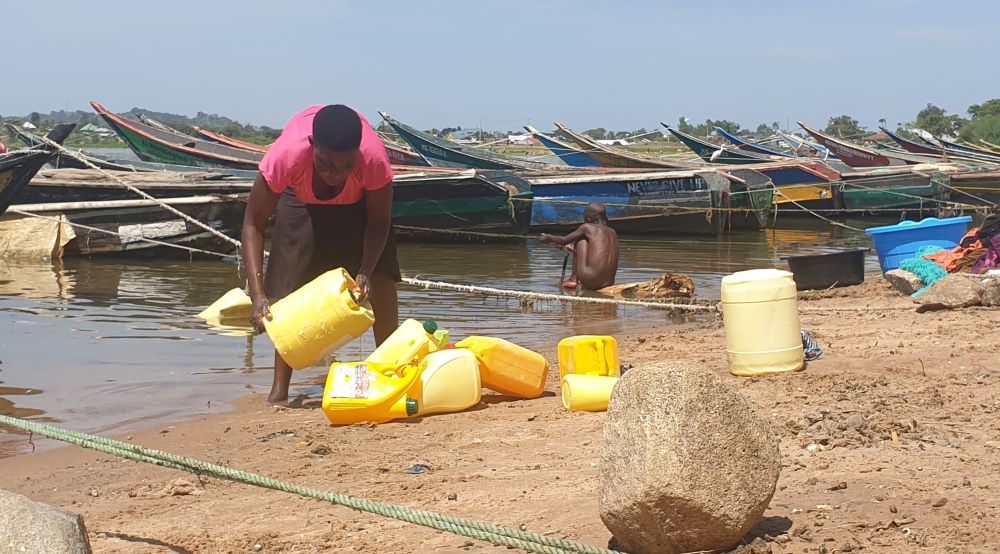 A woman cleans her utensils at Dunga Beach in Kisumu, Kenya. (Ian Byron)