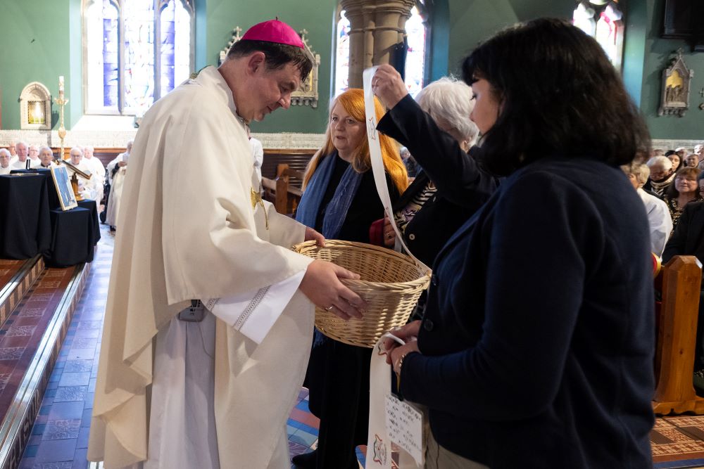 Bishop Stephen Wright, the new leader of the Hexham and Newcastle Diocese, accepts prayer ribbons representing victims of abuse during his installation service July 19.