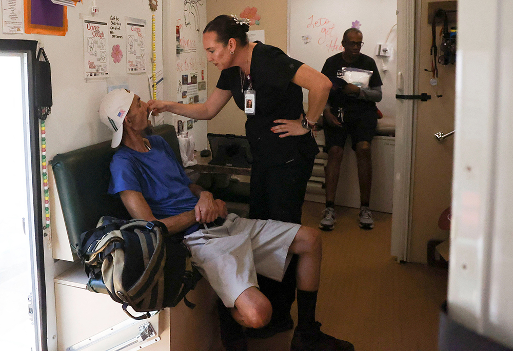 A man from a homeless encampment receives care from Circle The City's mobile medical unit on the 14th day of temperatures rising to 114 degrees F July 13 in Phoenix. Bishop Edward Weisenburger of the Diocese of Tucson, Arizona, calls climate change a critical topic. (OSV News/Reuters/Liliana Salgado)