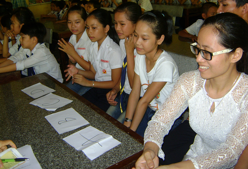 Apostolate Auxiliaries Sr. Mary Ton Nu Thu Tra (right) teaches catechism to children at Quang Ngan Parish, July 2 in Vietnam's Thua Thien Hue province. (GSR photo/Joachim Pham)