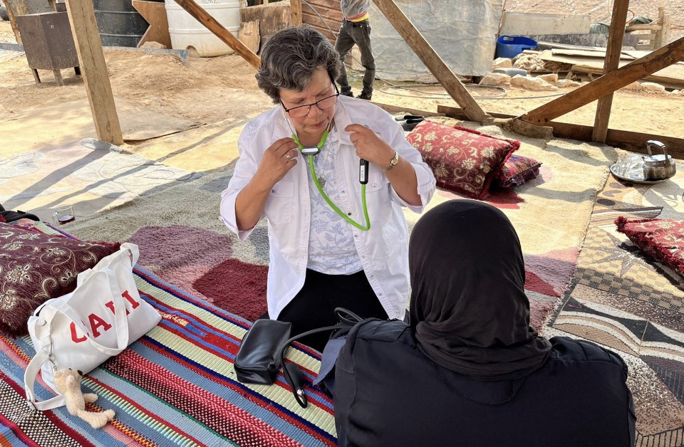 Sr. Julia Hurtado nurses an elderly bedouin at El Montar Bedouin Camp in the Judean Desert.