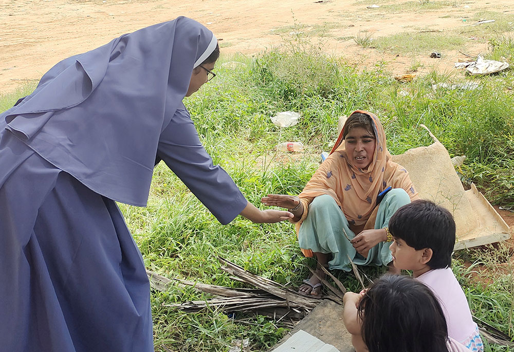 Poor Handmaids of Jesus Christ Sr. Bindu Jose at the garbage dumping yard in Bellahalli tries to recruit students to her early learning center at the outskirts of Bengaluru in southern India. (GSR photo/Thomas Scaria)