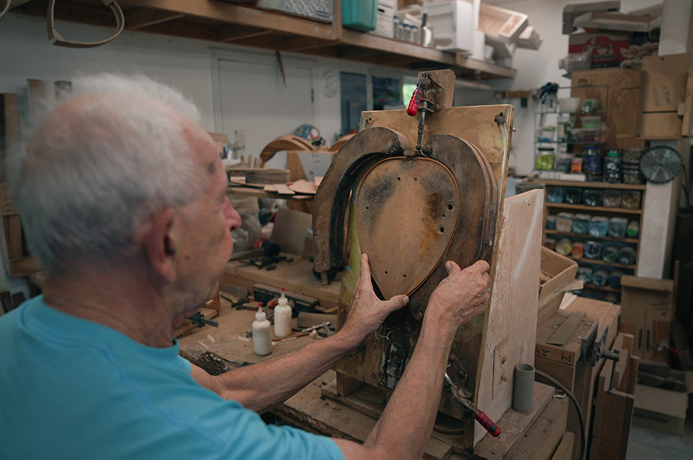 Mike Dulak bends a piece of wood to shape the frame of a mandolin, in his workshop in Rocheport, Missouri, Sept. 8. (AP/Jessie Wardarski)