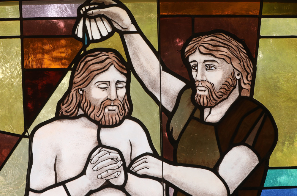 The baptism of Christ by John the Baptist is depicted in a stained-glass window at St. Anthony's Church in North Beach, Md.. July 15, 2021. (OSV News photo/CNS file, Bob Roller)