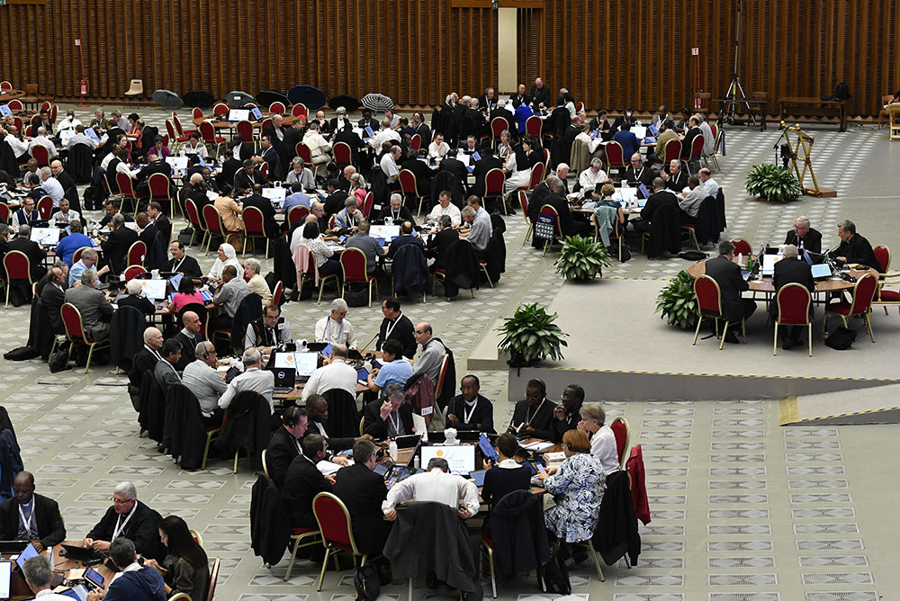 Participants at the assembly of the Synod of Bishops gather for prayer and discussion Oct. 21 in the Paul VI Audience Hall at the Vatican. (CNS/Vatican Media)