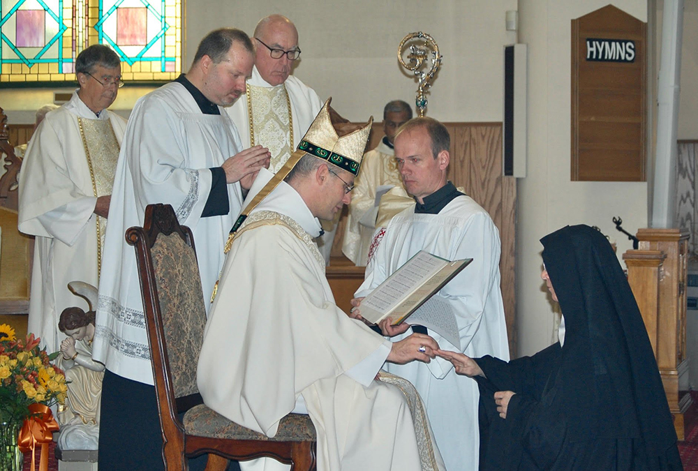 Dom Geoffroy Kemlin, abbot president of the Benedictines' Solesmes Congregation in France, places a ring on the finger of Benedictine Mother Benedict McLaughlin, abbess of Immaculate Heart of Mary Abbey in Westfield, Vermont, during her Nov. 11 abbatial blessing. (OSV News/Vermont Catholic magazine/Cori Fugere Urban)