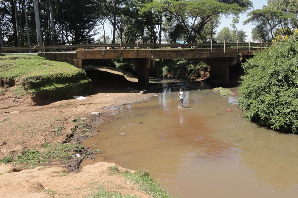 A man walks in the Murungato River in search of sand. The Kalondon River splits from the Murungato River toward Mathari. (Courtesy of Shadrack Omuka)