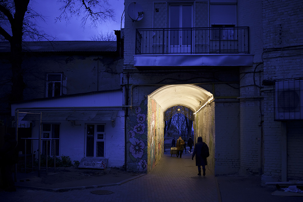 People walk through an alleyway at dusk in central Kyiv, Ukraine, Nov. 18. (AP/Felipe Dana)