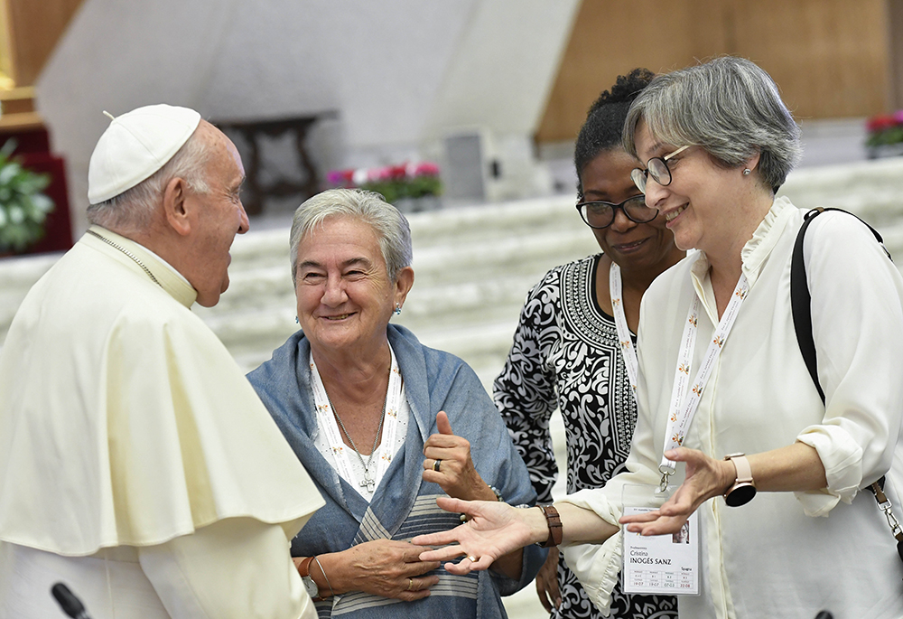 Pope Francis shares a laugh with some of the women members of the assembly of the Synod of Bishops, including Spanish theologian Cristina Inogés Sanz, left, at the assembly's session Oct. 6 in the Paul VI Audience Hall at the Vatican. (CNS/Vatican Media)