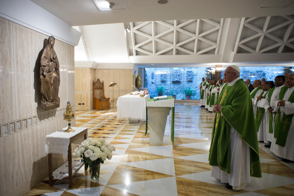 Pope Francis, wearing a green vestment, stands in front of a reliquary and sculpture of the Madonna and child