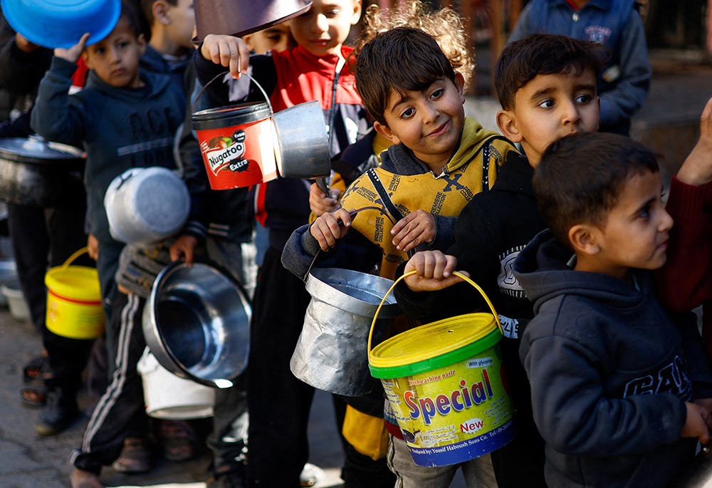 Displaced Palestinian children wait to receive food at a distribution center In Rafah in the southern Gaza Strip Jan. 16, amid the ongoing conflict between Israel and the Palestinian Islamist group Hamas. (OSV News/Reuters/Ibraheem Abu Mustafa)