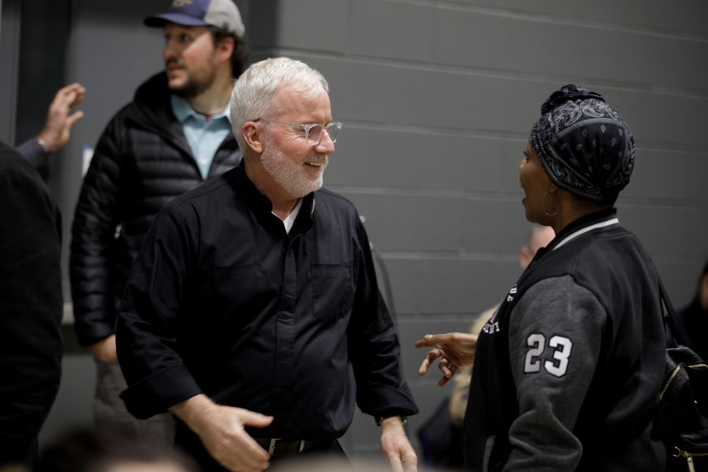 Jesuit Fr. Tim McCabe talks with a visitor to the Pope Francis Center in Detroit. The center will open its Bridge Housing Campus in May. 