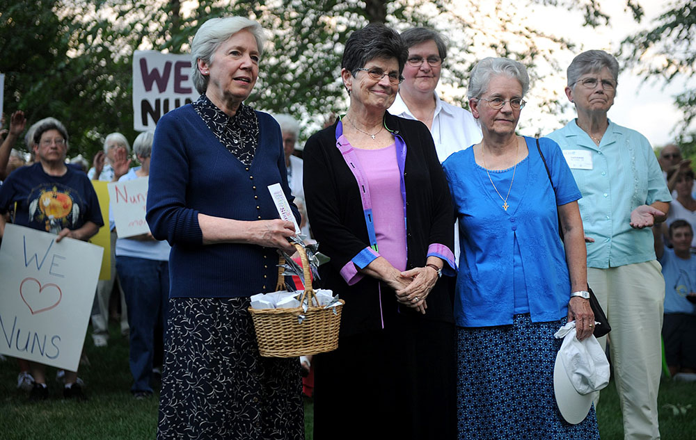 On Aug. 9, 2012, Dominican Sr. Mary Hughes, at the time past president of the Leadership Conference of Women Religious, left, joins Franciscan Sr. Pat Farrell, then LCWR president, and Franciscan Sr. Florence Deacon, then president-elect, as supporters offer a blessing at a rally during LCWR's 2012 assembly in St. Louis. (CNS/Sid Hastings)