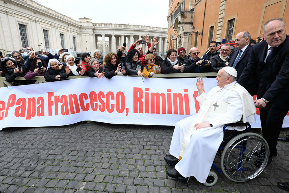 As Pope Francis exits the Paul VI Audience Hall after his weekly general audience at the Vatican Feb. 28, 2024, a group of people greet him. (CNS/Vatican Media)