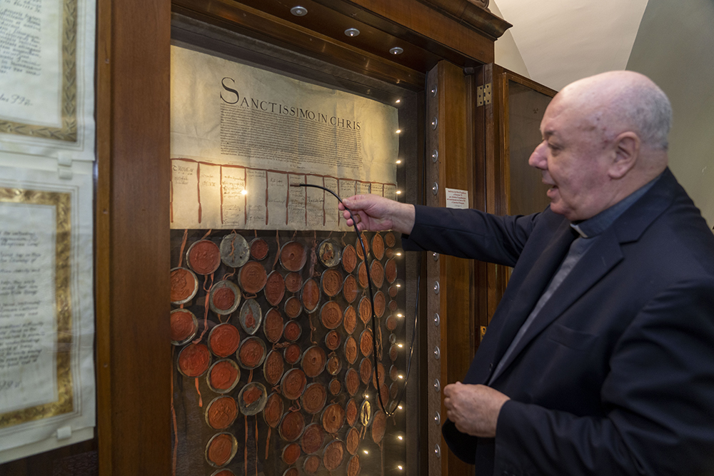 Prefect of the Archivio Apostolico Vaticano, Bishop Sergio Pagano shows the original 1530 letter kept in his office at the Vatican Feb. 14, 2024, and signed and sealed by the overwhelming majority of the House of Lords that attempted to pressure Pope Clement VII into granting the divorce to King Henry VIII of England from his wife Catherine of Aragon that was famously denied. (AP/Domenico Stinellis)