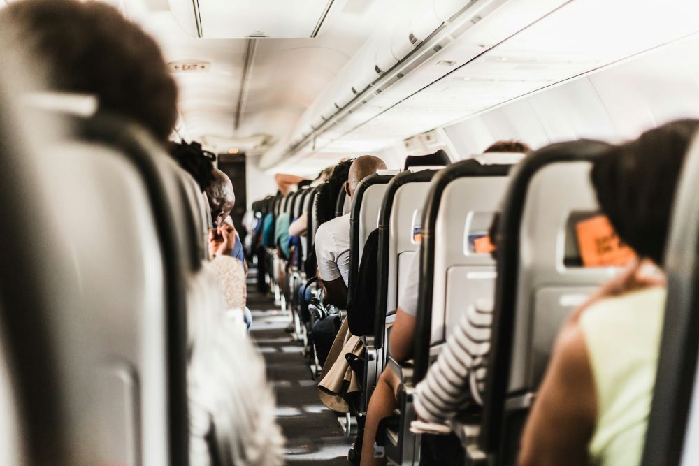 Inside airplane, people sit in seats.