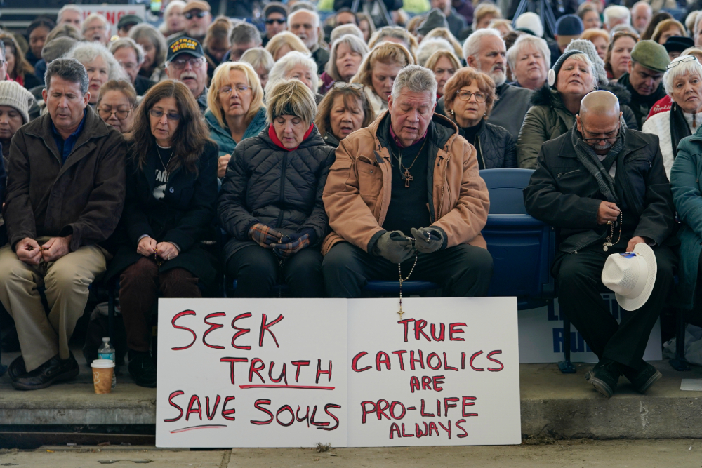 People pray rosary outside US Bishops Conference meeting in Baltimore.