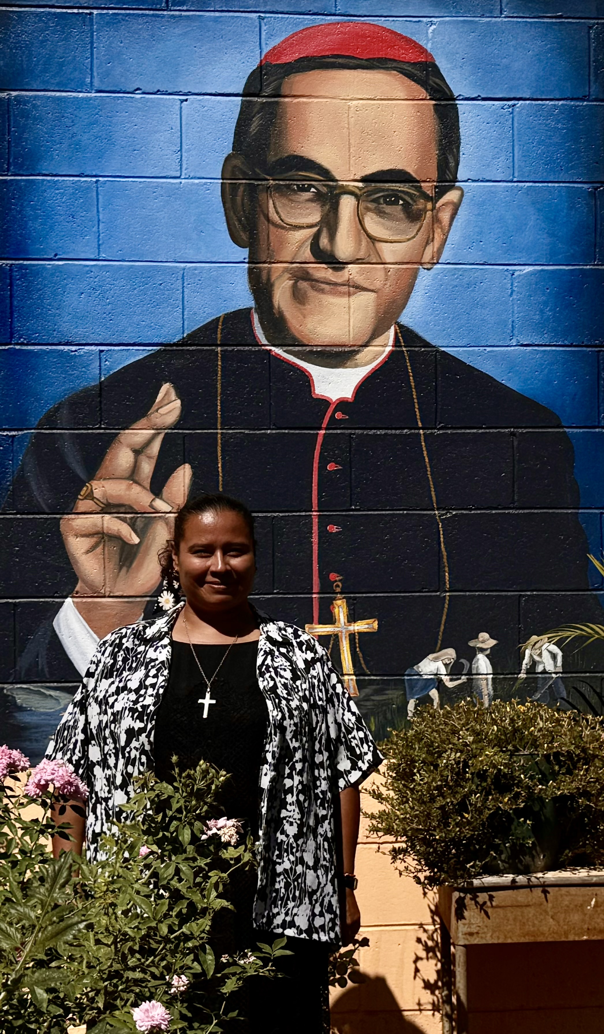 La Hna. Sandra Margarita Sierra Flores, de la Congregación de Notre Dame, posa para una foto frente a un mural de san Óscar Romero el 27 de enero de 2024 en Chalatenango, El Salvador.  La religiosa dice que ha encontrado inspiración en la vida del santo, sus escritos y su devoción a los pobres. (Foto: GSR/Rhina Guidos)