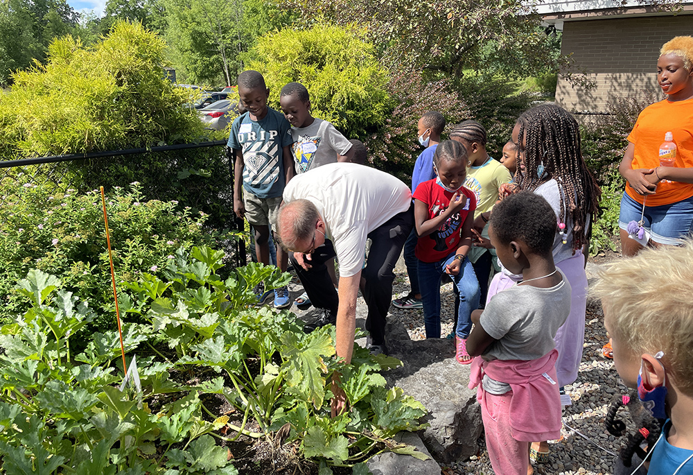 Fr. Frederick Daley, pastor of All Saints Church, with some of the Congolese refugees of the environmental youth group sponsored by the task force, in Syracuse, New York, in summer 2023 (Courtesy of Michael Songer)