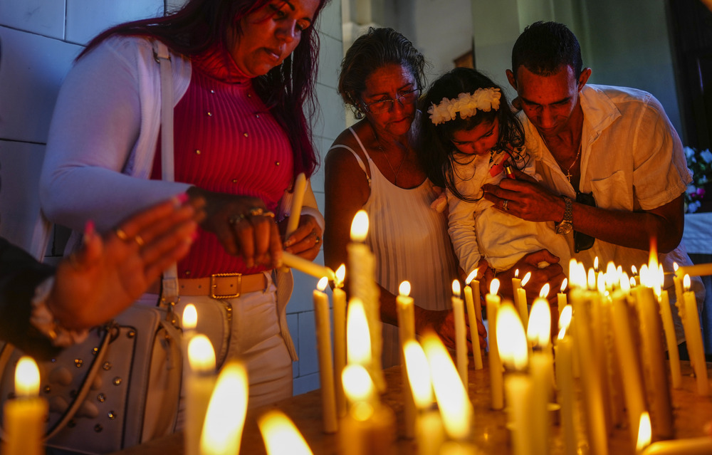 Devotees light candles at shrine of the Virgin of Charity in El Cobre, Cuba. 